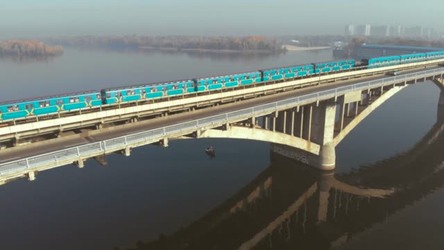 Zwei-U-Bahn-Züge-überqueren-einen-breiten-Fluss-über-die-Brücke