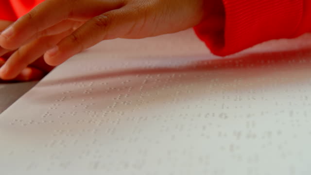 Nahaufnahme-der-blinden-asiatischen-Schülerinnen-und-Schüler,-die-ein-Braille-Buch-im-Klassenzimmer-der-Schule-4k-lesen