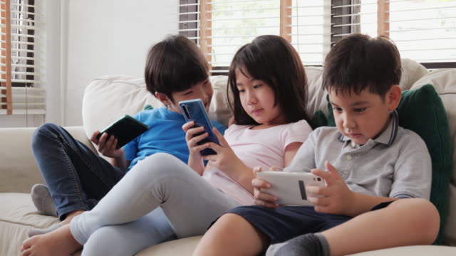 Gruppe-von-Kindern-Freund-mit-Smartphone-zu-spielen-gemeinsam-zu-Hause.-Kinder-spielen-Spiel-mit-glücklicher-Emotion.