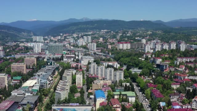 Aerial-video-shooting.-Panoramic-bird's-eye-view-of-the-city-center-of-Sochi.-Clear-sunny-day.-City-on-the-background-of-high-mountains.-Dense-building.-New-and-old-houses.