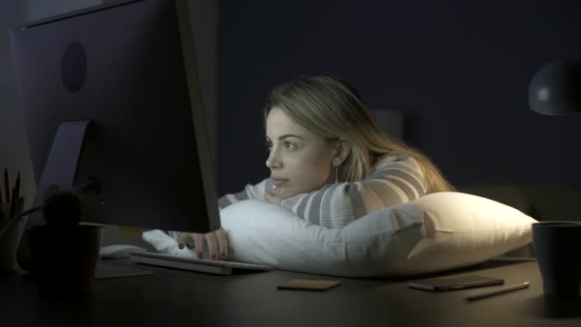 Sleepy-woman-leaning-on-a-pillow-on-the-desk