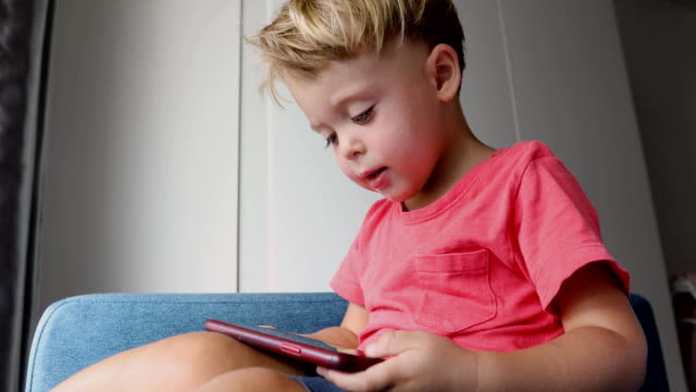 Contenido-niño-jugando-smartphone-en-el-sofá