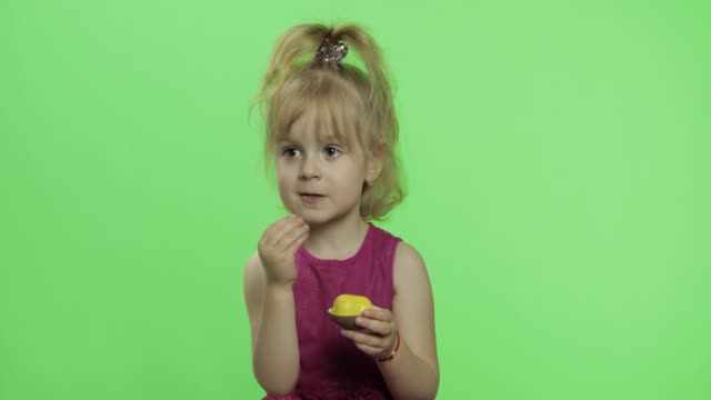 Mädchen-in-lila-Kleid-mit-Schokolade-Ei.-Glückliches-vierjähriges-Kind.-Chroma-Schlüssel