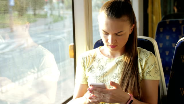 Portrait-of-attractive-serious-girl-in-train-using-smartphone-chatting-with-friends-woman.-Slow-motion