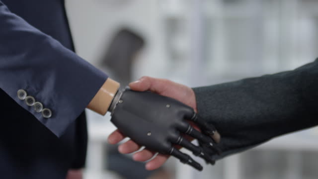 Handshake-of-Businessman-with-Bionic-Hand-and-His-Colleague