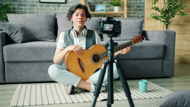 Kreative-Teenager-Aufnahme-Video-über-Gitarre-halten-Instrument-sprechen