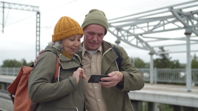 Seniors-Using-Phone-on-Train-Station