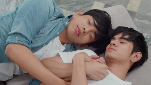 Junge-asiatische-homosexuell-Paar-schlafen-zusammen-zu-Hause.-Teen-korean-LGBTQ-Männer-glücklich-entspannen-Ruhe-liegen-auf-dem-Bett-im-Schlafzimmer-im-Haus-am-Morgen.