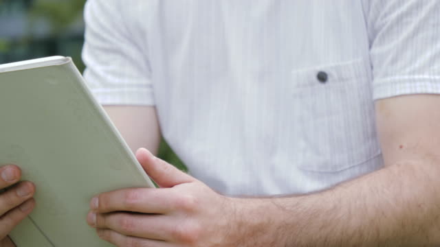 Man-touching-screen-on-modern-digital-tablet-pc-outdoors