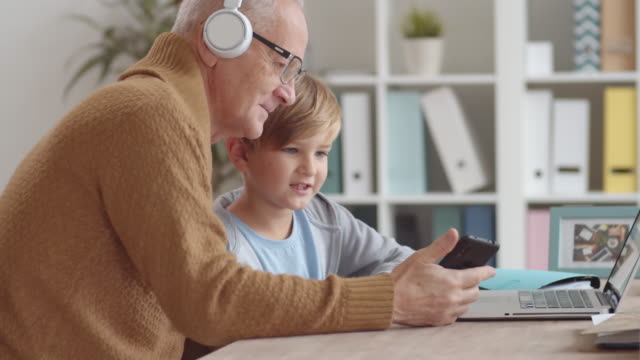Niño-enseñando-a-su-abuelo-cómo-usar-las-tecnologías