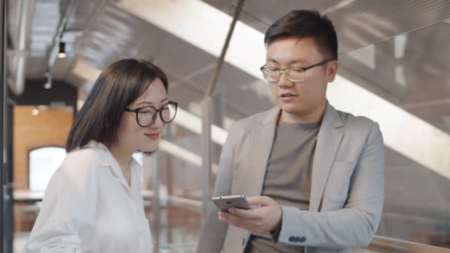 Two-Asian-Businesspeople-Using-Phone