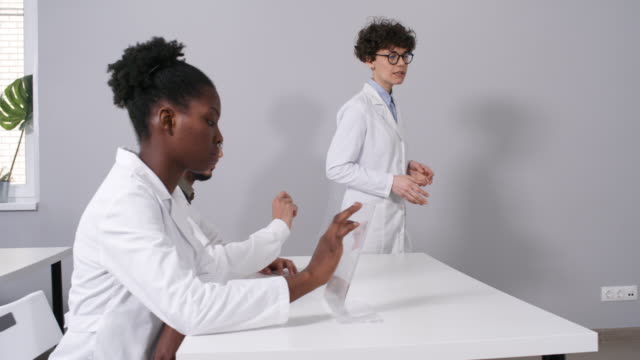 Teacher-in-Lab-Coat-Giving-Lecture-to-Students-with-AR-Interactive-Devices