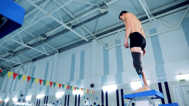 A-male-with-a-prosthetic-leg-is-preparing-to-swim-in-a-pool
