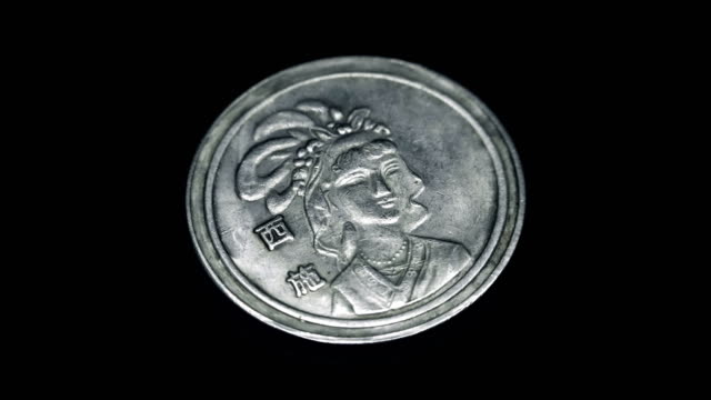 Moneda-antigua-de-China-(yuan)-gira-sobre-un-fondo-negro.-Macro.-Closeup