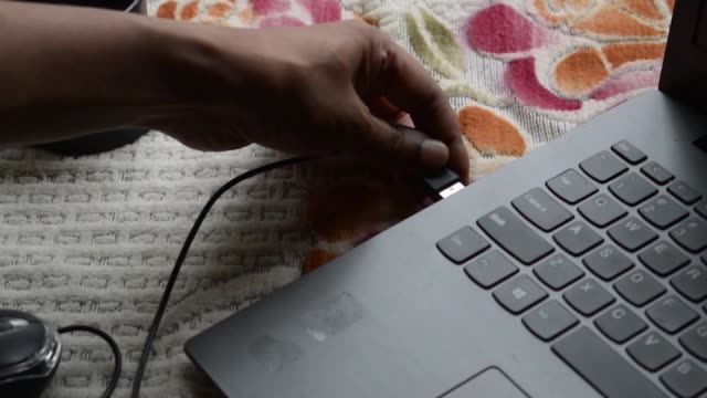 Human-hand-connecting-Computer-mouse-connection-cable-plug-in-the-laptop-keyboard.-Network-connection-plugin-internet-of-things-and-modern-wireless-technology-backgrounds.
