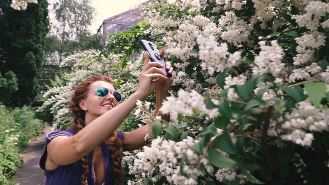 Smartphone.-A-young-woman-takes-flowers-on-a-smartphone.