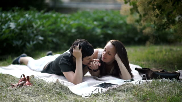Two-lesbians-relaxing-on-the-green-grass-in-park