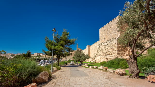 Defensive-wall-of-the-ancient-holy-Jerusalem-timelapse-hyperlapse,-lit-by-the-bright-sun.-Wonderful-green-lawn