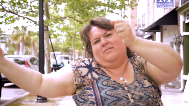 Very-happy-overweight-woman-urban-dancing-and-jammin-in-the-streets-of-a-city