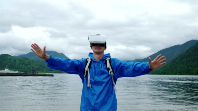 Ein-Mann-nutzt-virtual-Reality-Brille-auf-dem-Hintergrund-eines-Bergsees