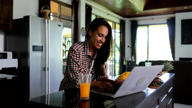 Mädchen-Verwendung-Laptop-Computer-innen-Küche-im-Chat-Online-junge-Frau-Studio-modernes-Haus