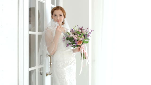 Bride-shyly-covers-her-face-with-a-veil.