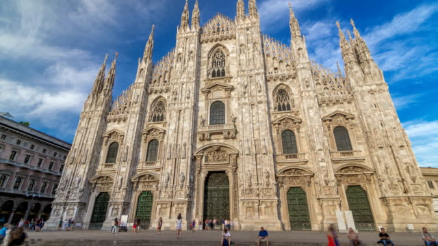 The-Duomo-cathedral-timelapse-hyperlapse-at-sunset.-Front-view-with-people-sitting-on-stairs