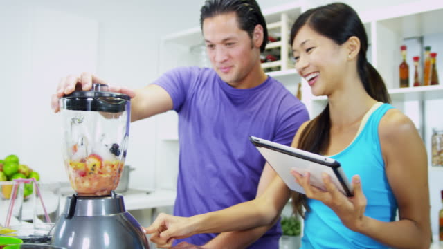 Healthy-Ethnic-couple-using-tablet-recipe-homemade-smoothie