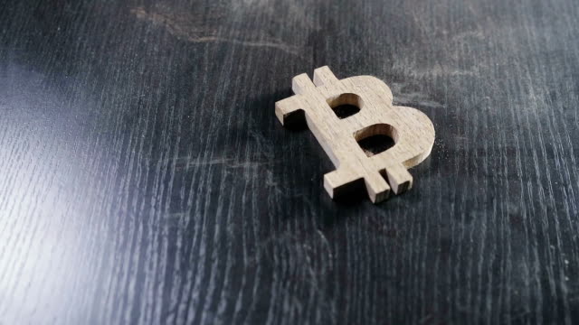 the-wooden-bitcoin-symbol-lies-on-a-dusty-table