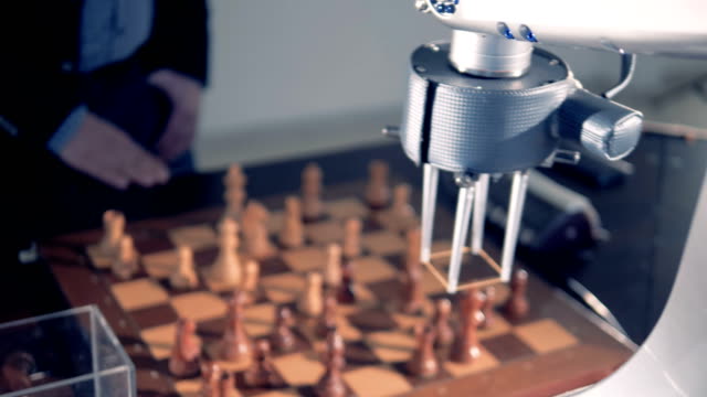 Close-up-view-on-robotized-arm-playing-chess.
