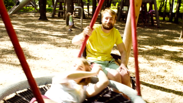 Woman-is-lying-on-a-swing-and-a-man-is-pushing-a-swing