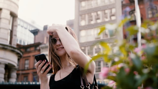 Happy-aufgeregt-kaukasischen-Bloggerin-in-Sonnenbrille-mit-Smartphone-app-Einkaufen-berühren-Haare-im-Sommer-New-York