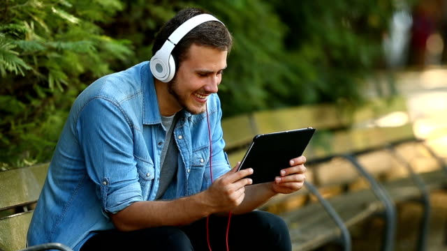 Guy-entspannend-ansehen-von-Videos-auf-Linie-in-einer-Tablette
