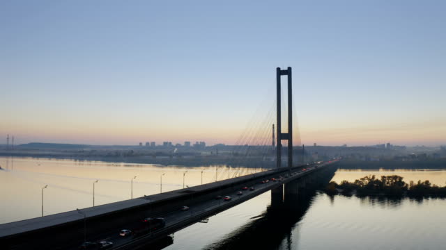 Puente-de-la-ciudad-de-Kiev-antena-con-tráfico-de-la-ciudad-al-atardecer