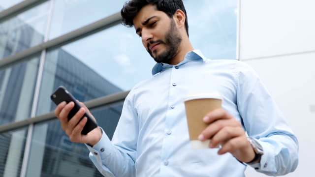 Business-Man-With-Phone-And-Coffee-Near-Business-Office