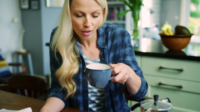 Schöne-blonde-Frau-Überprüfung-Smartphone-beim-Kaffeetrinken