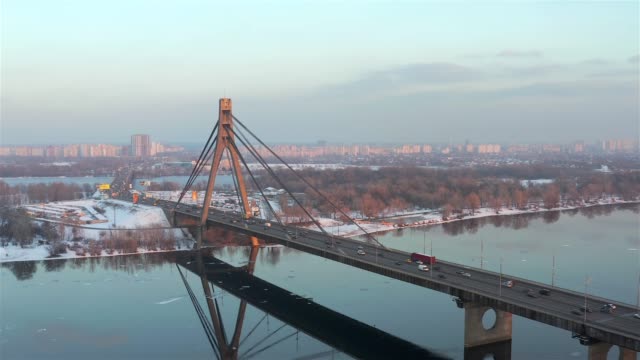 Vista-aérea-de-puente-norte-y-el-río-de-Dnieper-de-la-ciudad-de-Kiev-al-atardecer-en-invierno,-Ucrania