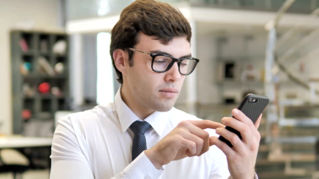 Young-Businessman-Using-Smartphone,-Typing-Message