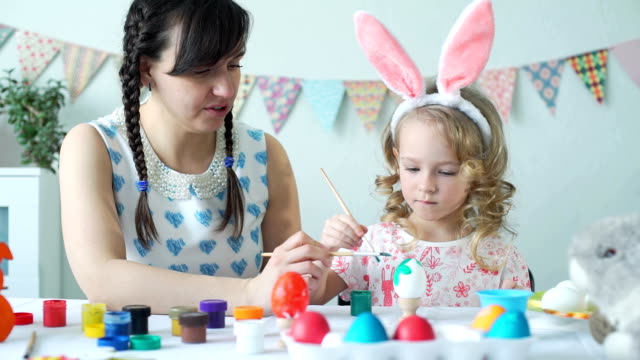 Little-Girl-Decorating-Easter-Eggs-with-Mother