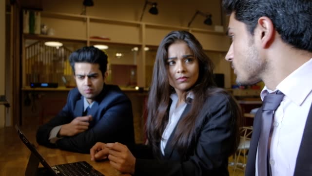 Los-jóvenes-colegas-indios-se-reúnen-mientras-idean-e-interactúan-en-una-computadora-para-trabajar-y-encontrar-ideas-y-trabajar-y-presentar-una-propuesta-con-un-plazo-pendiente-de-trabajo-y-concentrado