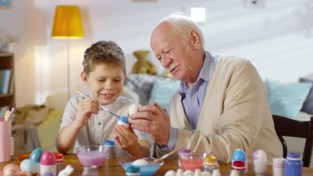 Niño-pintando-huevos-de-Pascua-con-el-abuelo