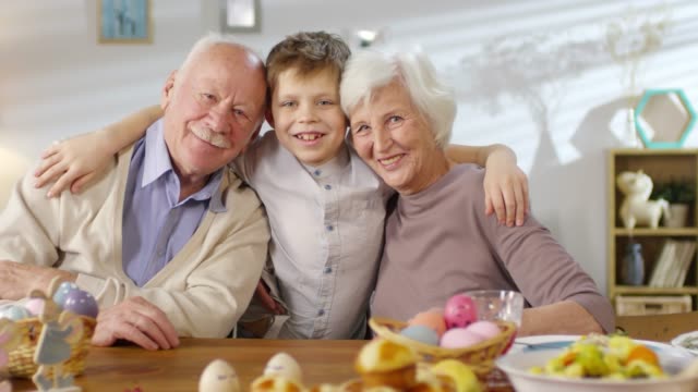 Porträt-von-Enkel-Hugging-Großeltern-und-Smiling