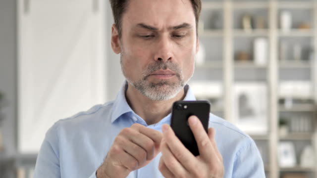 Senior-Aged-Businessman-Using-Smartphone,-Typing-Message
