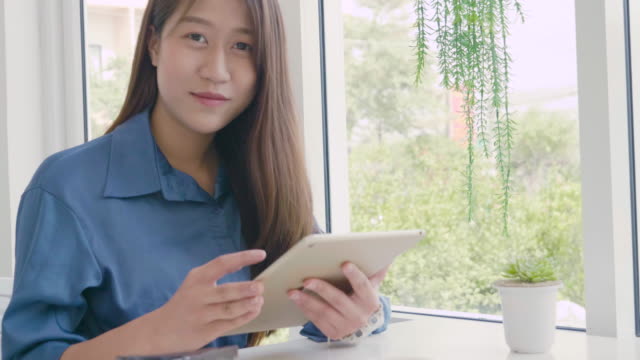 Mujer-asiática-chica-joven-mirando-lectura-en-la-tableta,-tecnología-de-medios-sociales