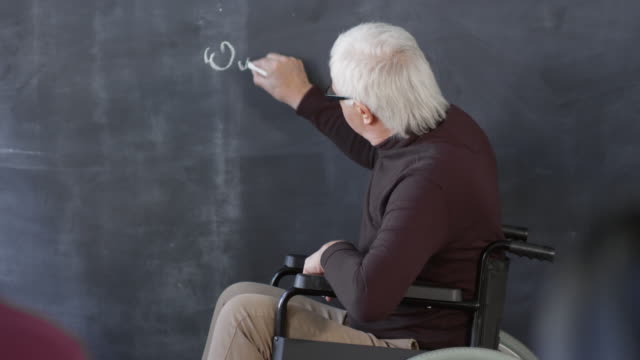 Behinderte-Professorin-schreibt-Gleichung-auf-Schwarzboard