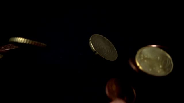 Münzen-fallen-auf-einen-schwarzen-Hintergrund.-zeitlupe.