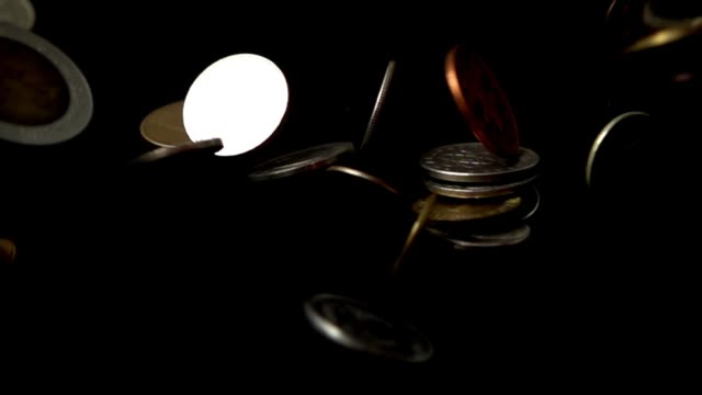 Coins-fall-on-a-black-background.-Slow-motion.