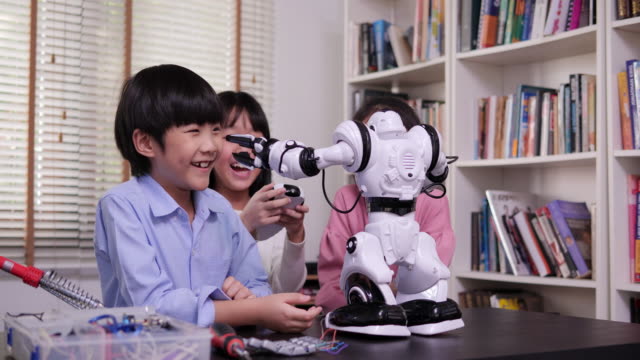 Gruppe-von-Schülern-arbeiten-an-einem-programmierbaren-Roboter-in-der-Schule-Wissenschaft-Klassenprojekt.-Technologie--und-Bildungskonzept.