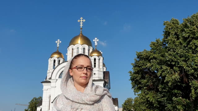 Mujer-de-estilo-de-vida-ortodoxa-en-una-bufanda-se-encuentra-en-el-fondo-de-la-Iglesia-Ortodoxa