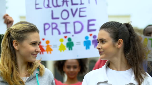 Female-couple-defending-rights-of-minorities,-same-sex-marriage,-pride-march